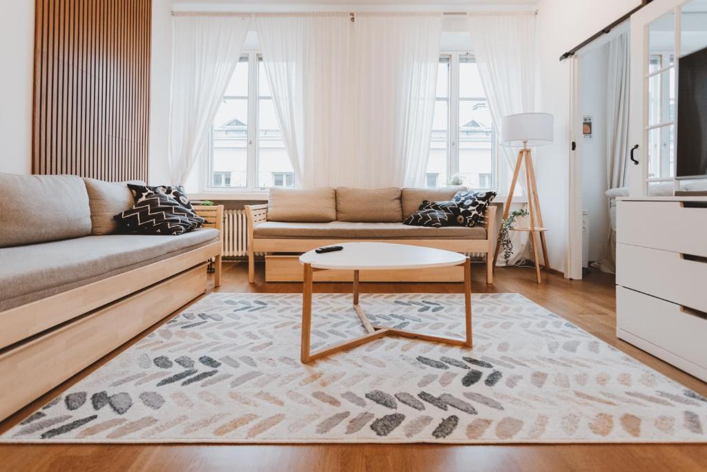 a living room with a couch and a coffee table at Scandic Primo Apartments - Eerikinkatu 46m2 in Helsinki