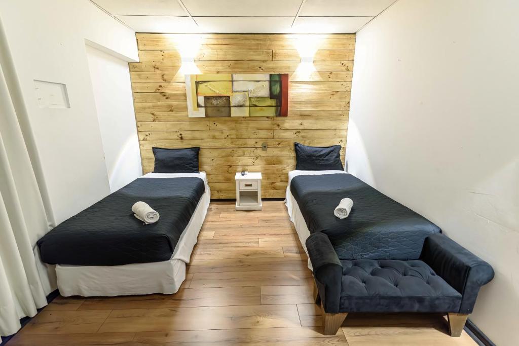 a room with two beds and a couch in it at Santa María Express in Santiago