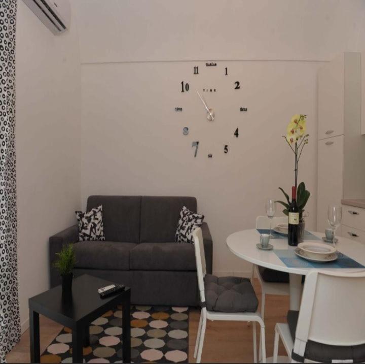 a living room with a couch and a clock on the wall at Casa vacanze Ecce Homo in Ragusa