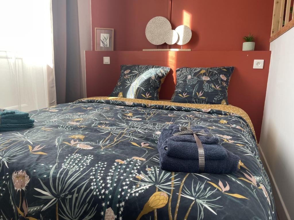 Un dormitorio con una cama con una bolsa azul. en Croix Rouge, en Châtellerault
