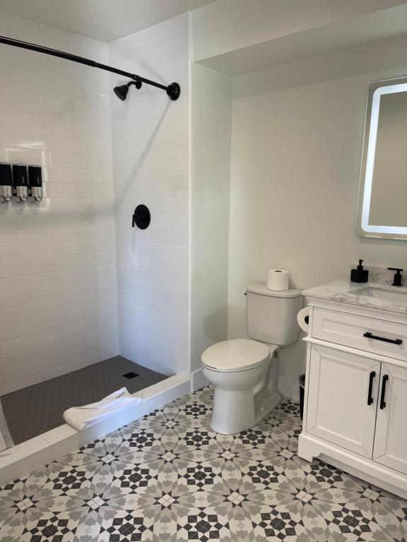 a white bathroom with a toilet and a shower at New Haven Inn in Solvang