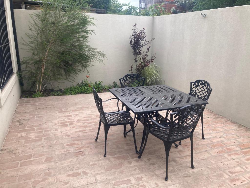 een zwarte tafel en stoelen op een patio bij Complejo Guido in San Antonio de Areco