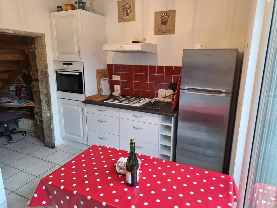 - une cuisine avec une table et une bouteille de vin dans l'établissement Maison en pierre proche mer, commerces et bus, à Pordic