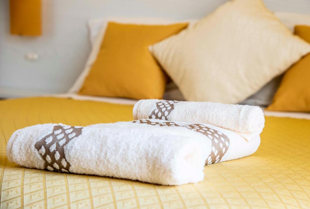 a stack of towels sitting on a bed at Blu Mare Lampedusa Bed And Breakfast in Lampedusa