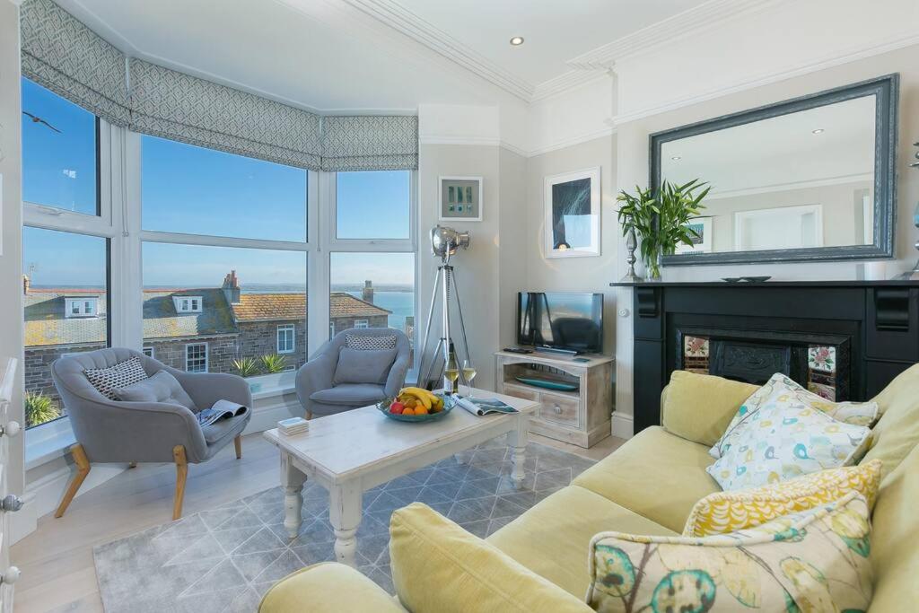 a living room with a couch and a fireplace at Sea Salt sea views parking in St Ives