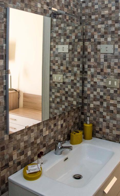 a bathroom with a sink and a large mirror at Blu Mare Lampedusa Bed And Breakfast in Lampedusa