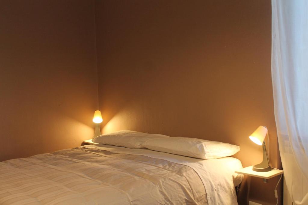 a bedroom with a bed with two lights on it at B&R Apartment in Caselle Torinese