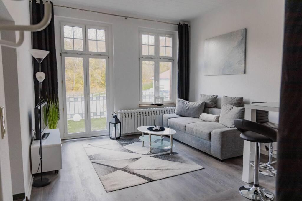 uma sala de estar com um sofá e uma mesa em Fewo Jule em Sondershausen