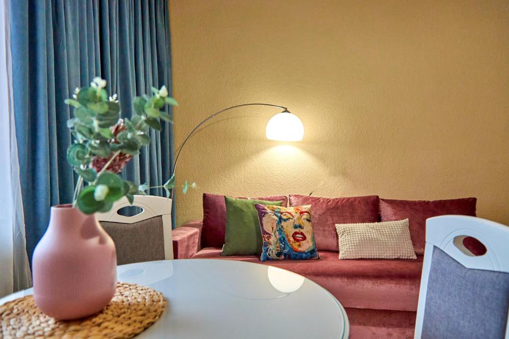 - un salon avec un canapé rose et une table dans l'établissement Amazing View Lux with balcony, à Moukatcheve