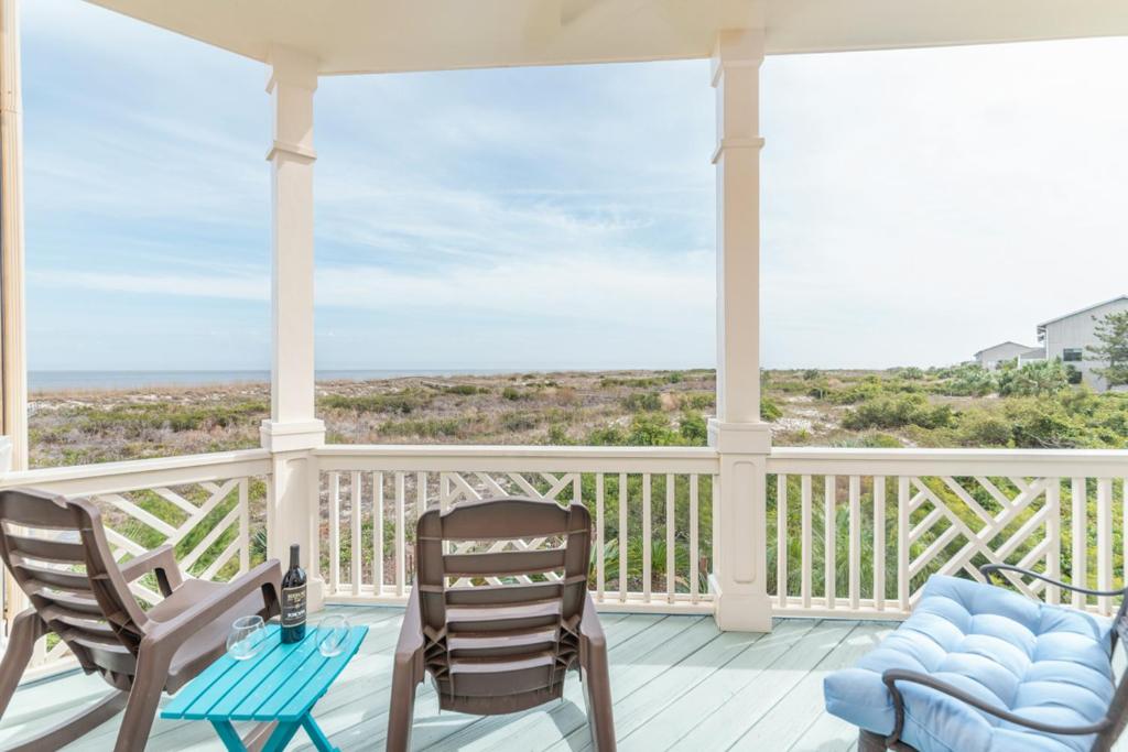 - une terrasse couverte avec 2 chaises et une table dans l'établissement Seascape on Harbor Island, à Oceanmarsh Subdivision