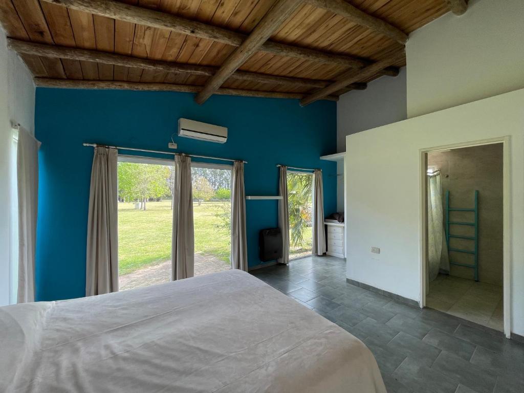 ein Schlafzimmer mit blauen Wänden und einem großen Bett in der Unterkunft Grand Zen Hotel in Loma Verde