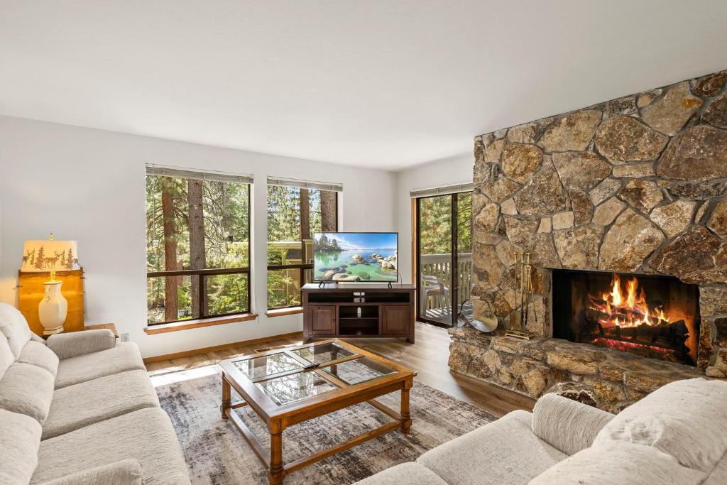 a living room with a large stone fireplace at 1 Sky Lake - walk to town in Incline Village