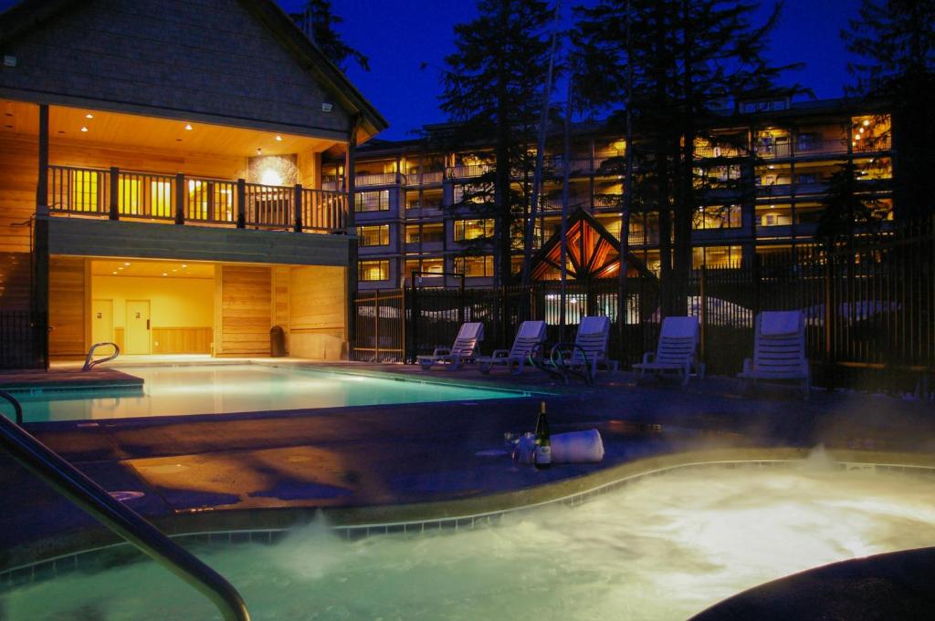a swimming pool with chairs and a building at #304 Grand Lodge South in Government Camp