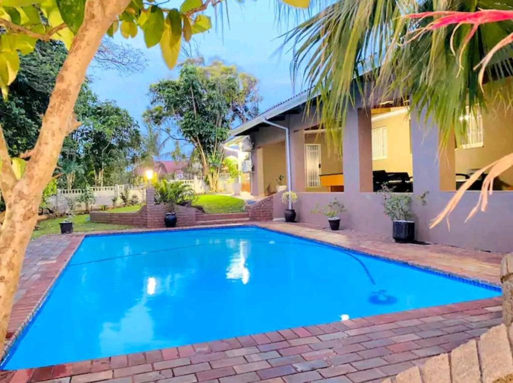 a swimming pool in front of a house at Listos Guest House in Empangeni