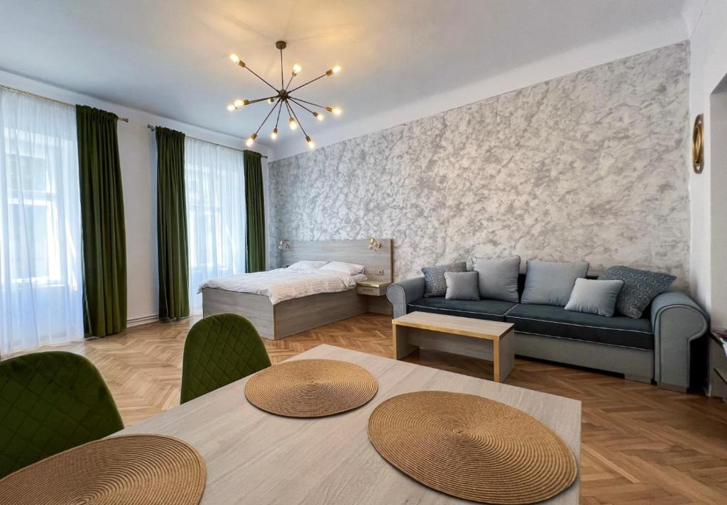 a living room with a couch and a bed at Studio Excelsior 1 in Sibiu