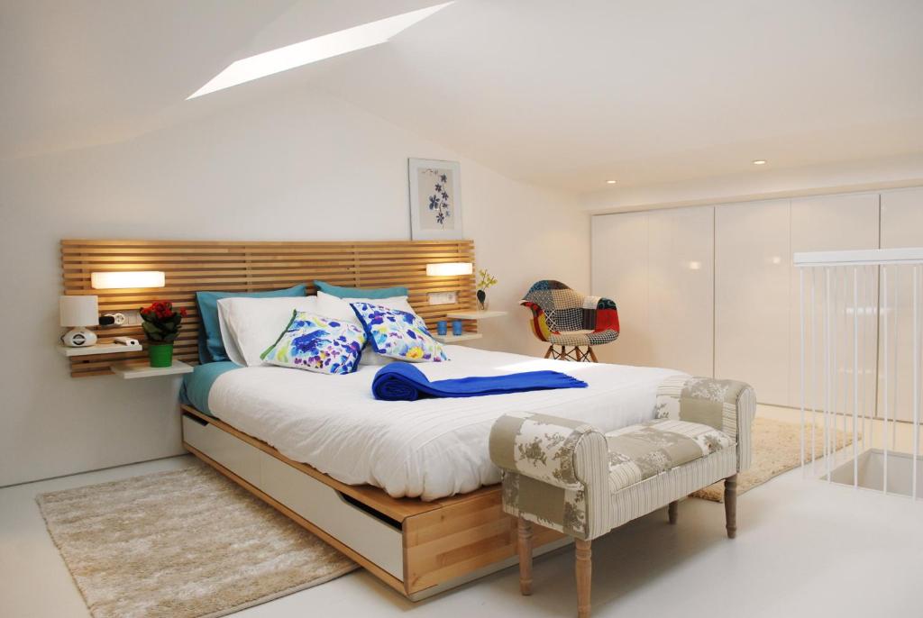 1 dormitorio con 1 cama grande y 1 silla en Blue Home, en Santiago de Compostela