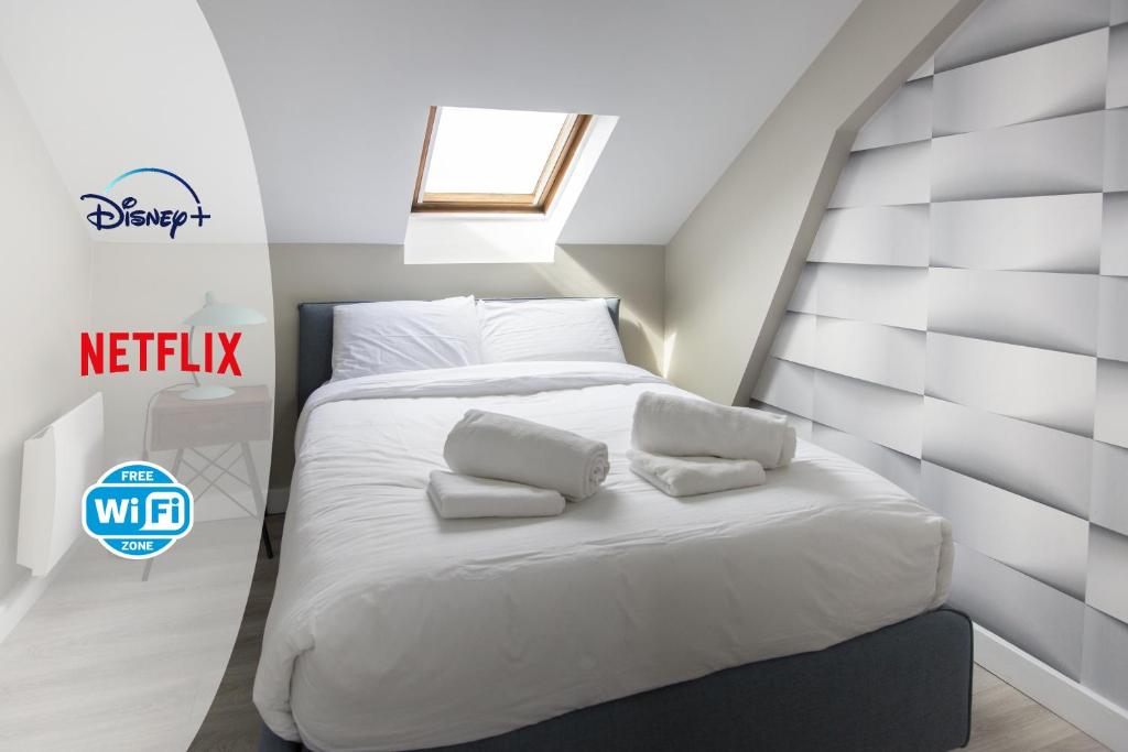 - une chambre avec un lit doté de draps et d'oreillers blancs dans l'établissement Modern apartement in the city center., à Poissy