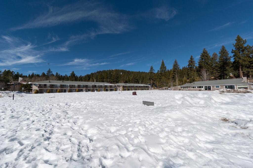 un campo cubierto de nieve con un edificio en el fondo en Tahoe Sands Resort en Tahoe Vista
