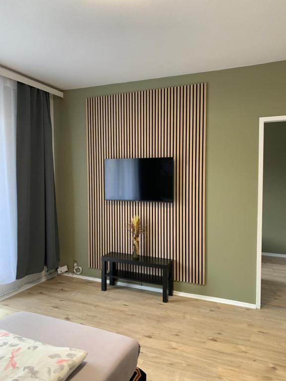uma sala de estar com uma televisão de ecrã plano na parede em Enjoy Berlin em Berlim