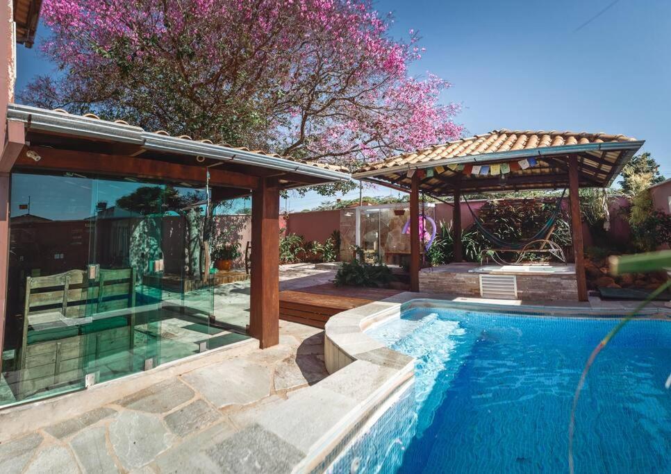 una piscina con cenador y una casa en CASA SPA Pirenópolis casa inteira en Pirenópolis