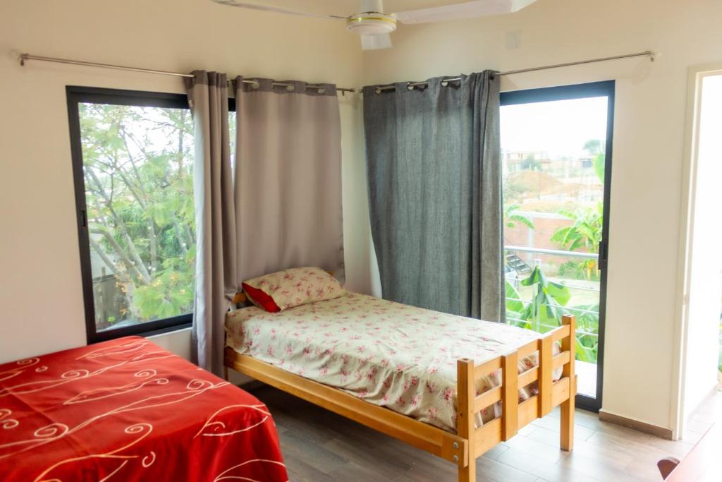 a bedroom with a bed and a large window at Casa Biznaga in Oaxaca City