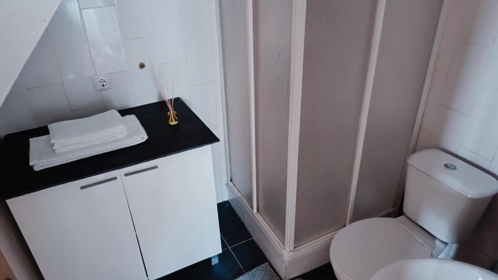 a bathroom with a white toilet and a black counter at Casa do Freire - Serra da Estrela in Aguincho