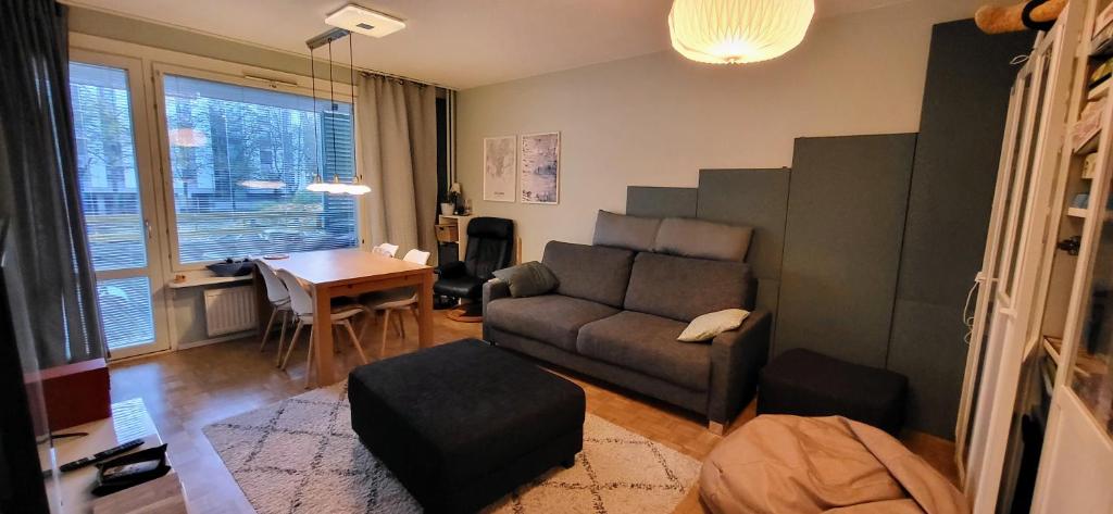 Cosy Big 2 room apartment في هلسنكي: غرفة معيشة مع أريكة وطاولة