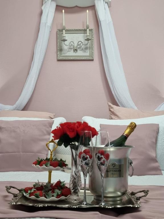 - un plateau avec des verres à vin et des fleurs sur le lit dans l'établissement La chatellenie Gîte de caractère de 1638., à Évaux-les-Bains