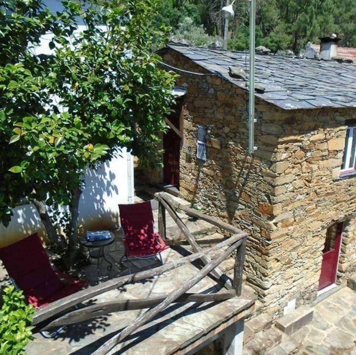 ein Steinhaus mit zwei Stühlen auf einer Veranda in der Unterkunft Casa do Galvão -Turismo Rural - Serra da Estrela in Aguincho
