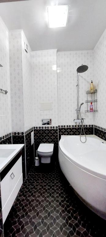 a bathroom with a tub and a toilet and a sink at Жк Нурсая 2комн.апартаменты in Atyrau