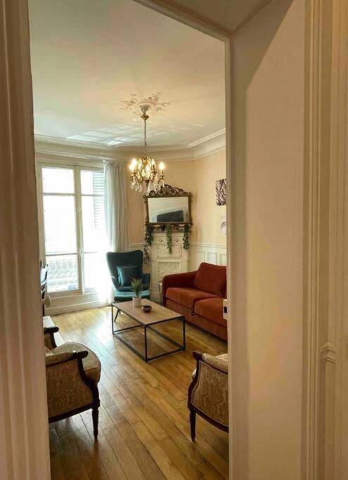 un salon avec un canapé et une table dans l'établissement Appartment Close to Monuments, à Paris