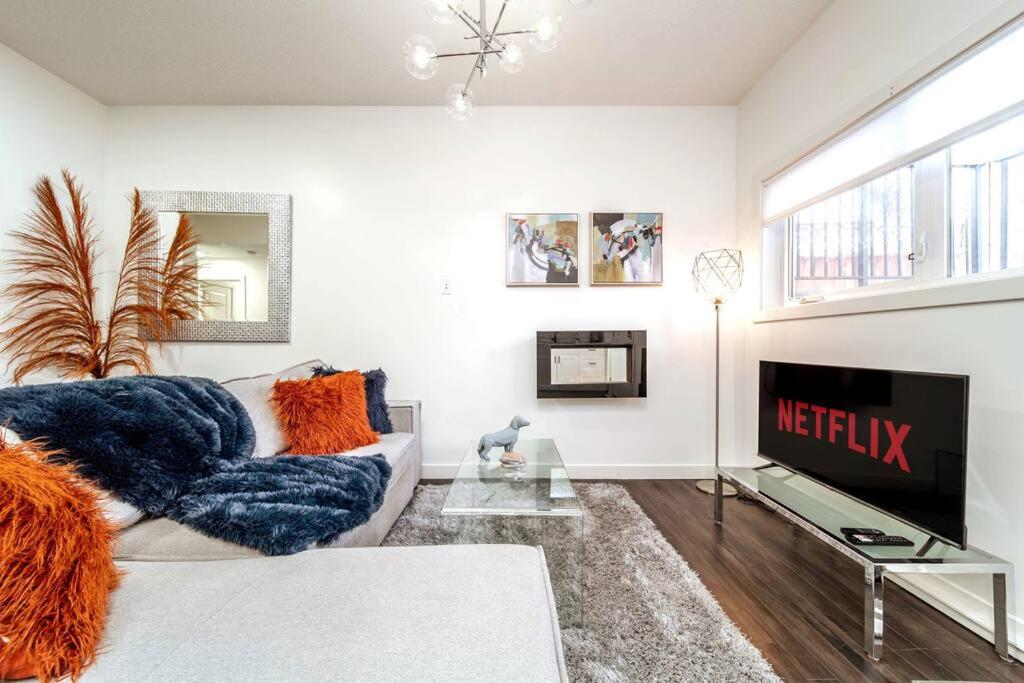 a living room with a couch and a tv at Chic Suite - Long Stays - King Bed - Fireplace & WiFi in Edmonton
