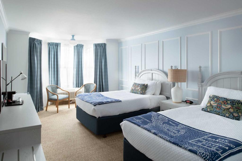 サンフランシスコにあるCoventry Motor Innのベッド2台とテーブルが備わるホテルルームです。