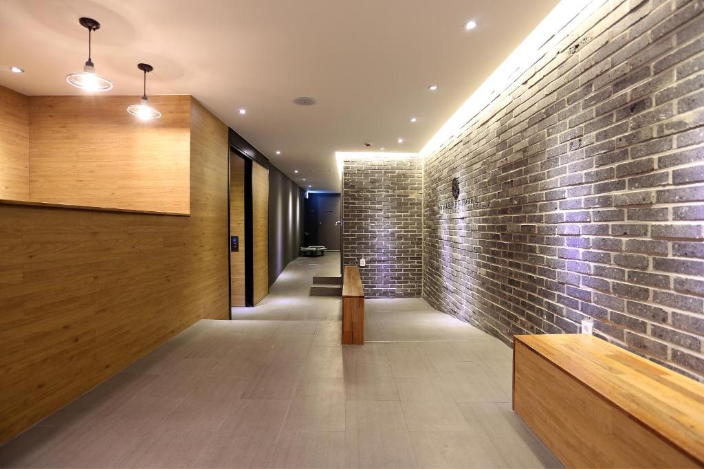 un muro di mattoni nel corridoio di una casa di Hotel 8 Hours a Seul