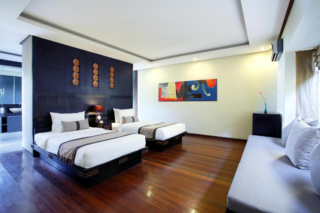 a hotel room with two beds and a couch at Lalasa Villas Canggu in Canggu
