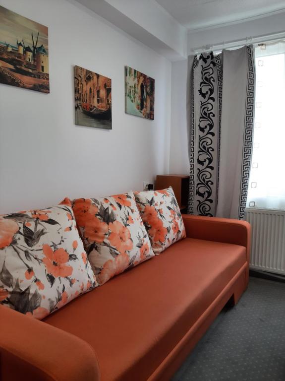 an orange couch in a living room with flowers on it at Arti Studio in Braşov