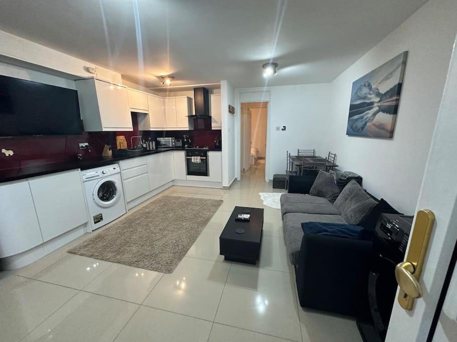 a living room with a couch and a kitchen at Lovely 1 bedroom flat in Chigwell