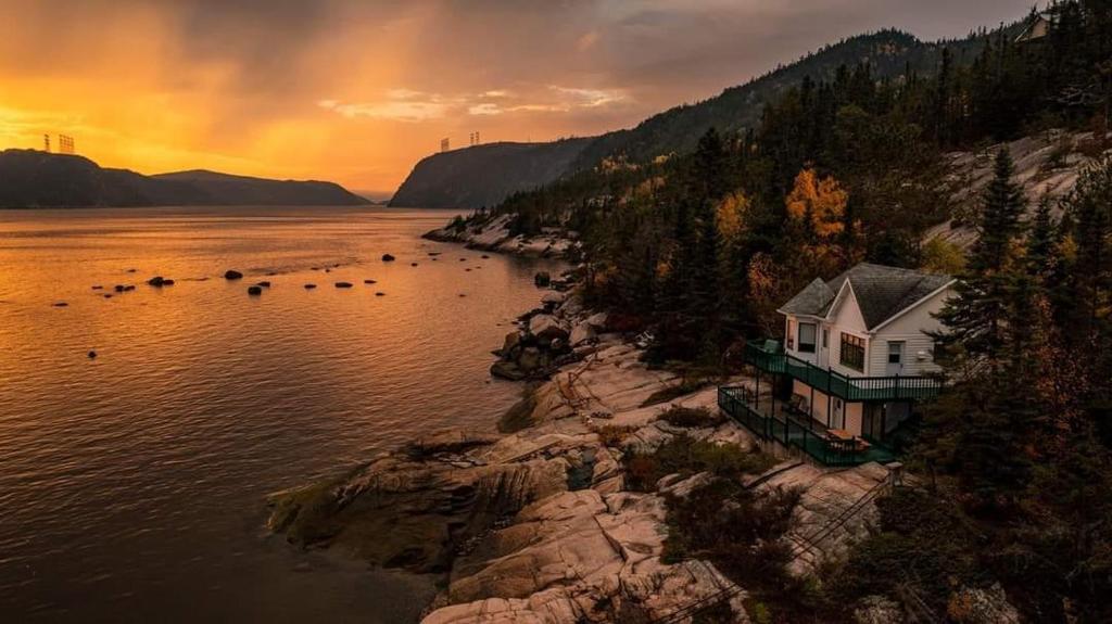 uma casa na costa de um corpo de água em Centre de Vacances 5 Étoiles Family Resort em Sacré-Coeur-Saguenay