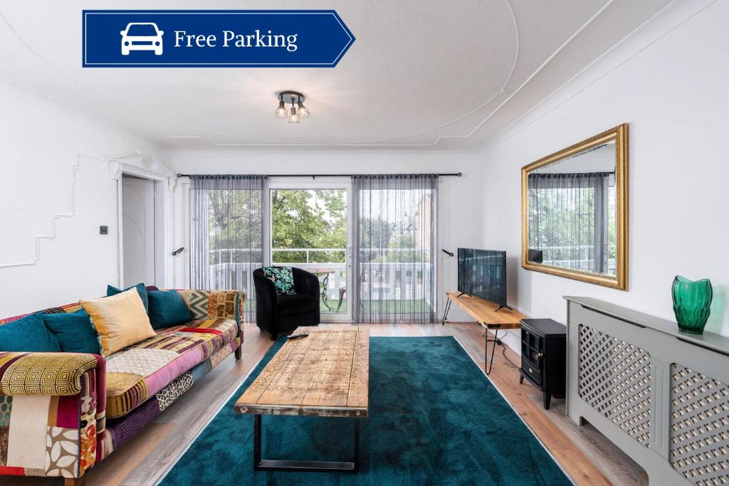 ein Wohnzimmer mit Sofa und Tisch in der Unterkunft Chic 3 BR Home with Balcony & Free Parking in Leeds