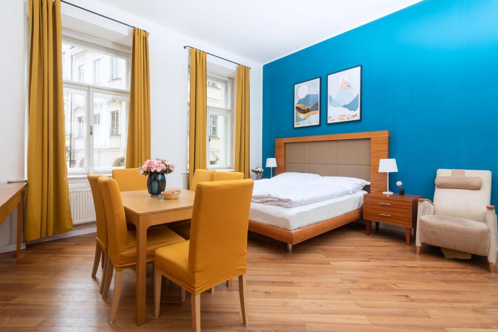 Moonlight Apartments Old Town في براغ: غرفة نوم بسرير وطاولة وكراسي