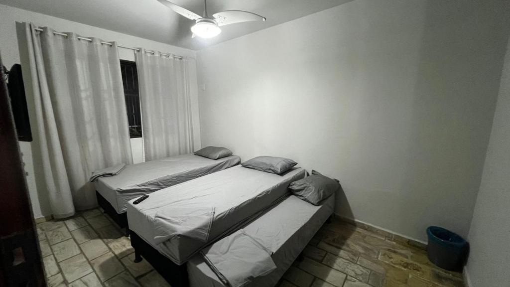 Sossai Hostel في فيتوريا: سريرين في غرفة صغيرة مع نافذة