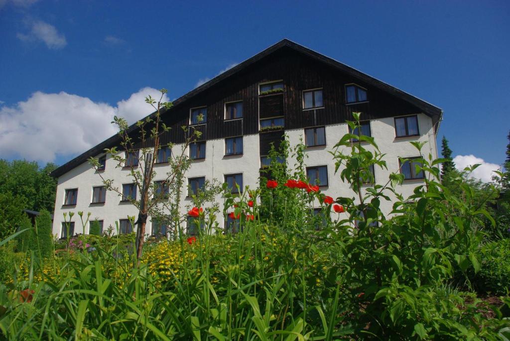 a large white building with a black roof at Hotel Forstmeister in Schönheide