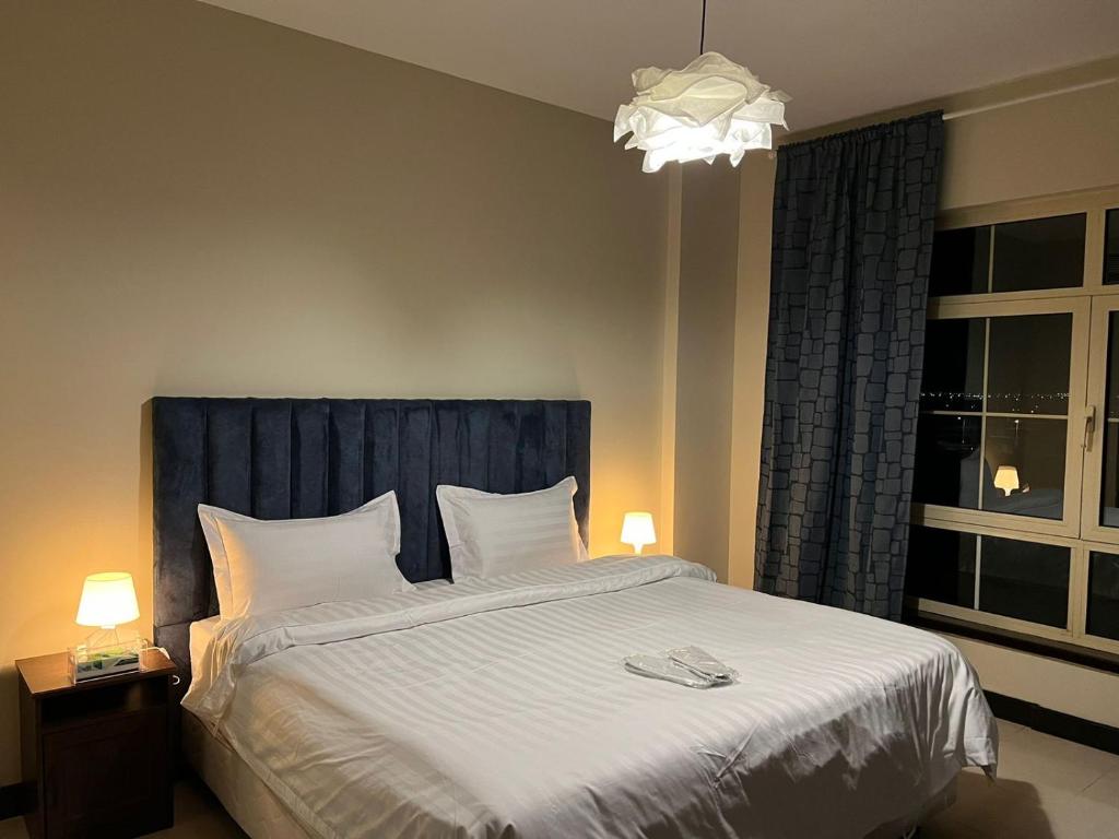 sypialnia z dużym łóżkiem z niebieskim zagłówkiem w obiekcie هافانا المارينا Apartment w mieście King Abdullah Economic City