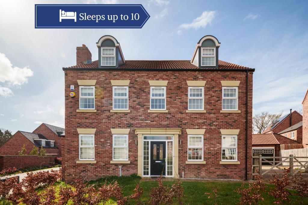 a brick house with a sign that says sleeps up to at Beautiful Big Family Home - Sleeps 10, Park 3 Cars in Meanwood