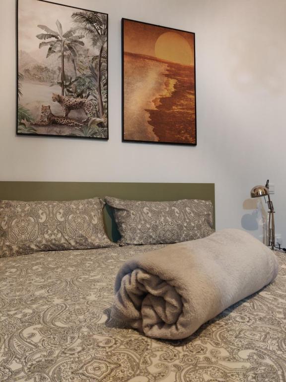 a bed with a blanket on it with three pictures on the wall at Central Malta Apartment in Birkirkara