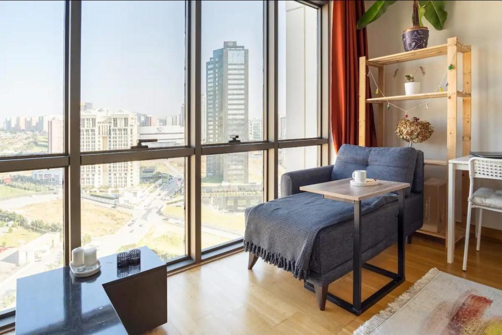 ein Schlafzimmer mit einem blauen Bett und einem großen Fenster in der Unterkunft Your Bright-Cozy&Luxury home Istanbul in Istanbul