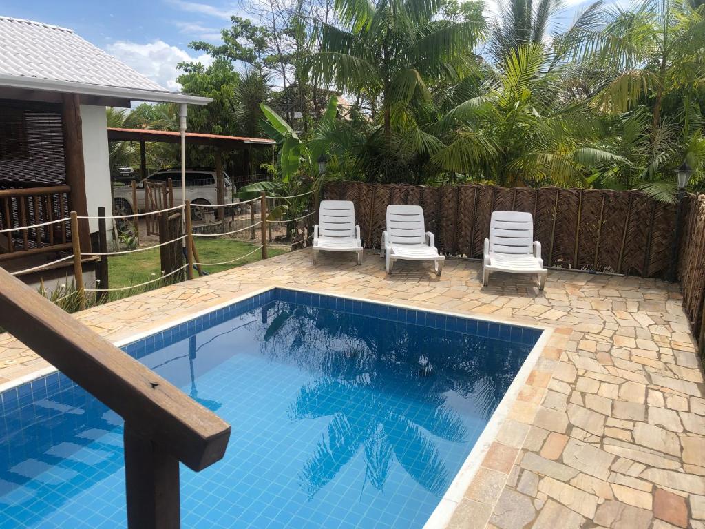 een zwembad met ligstoelen naast een huis bij Ao som do mar Bahia in Marau