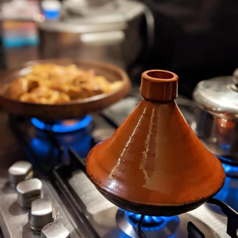 a pot on a stove with a pan of food at Dar Rafti in Fez