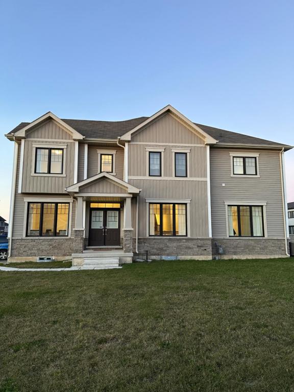 a large house with a large lawn in front of it at 4 Bedrooms new house sleep 12 fury friends welcome in Niagara Falls