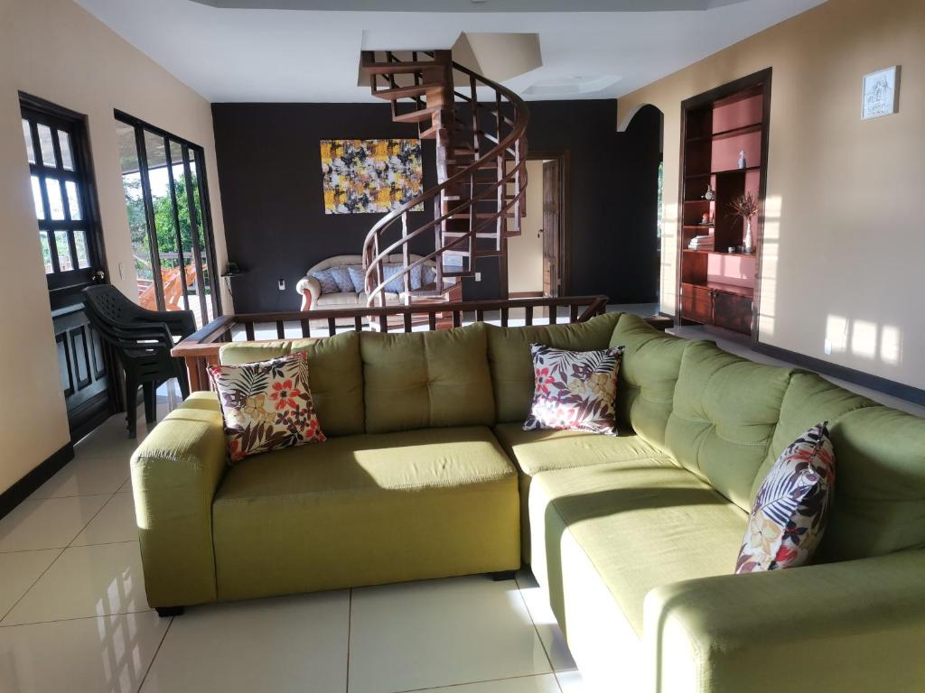 a living room with a green couch with pillows at House Susan in San Pedrillo